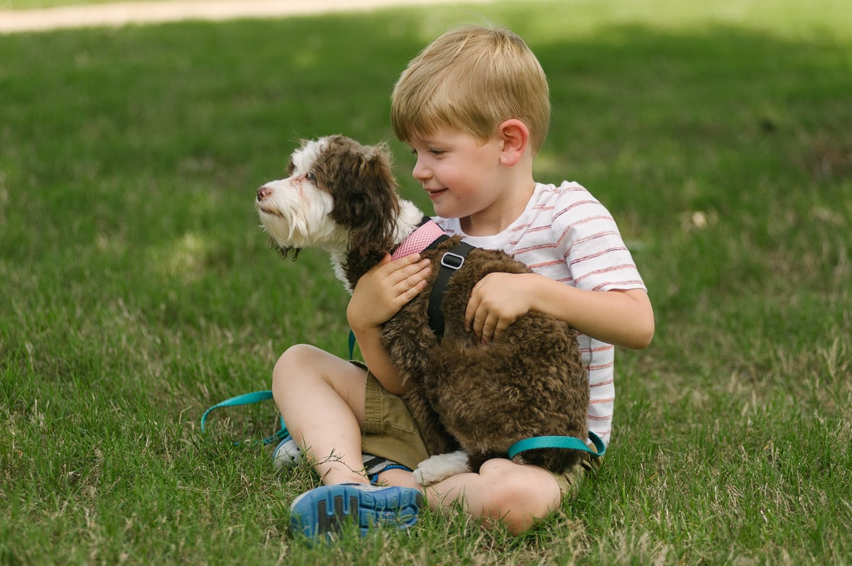 child holding dog on lawn