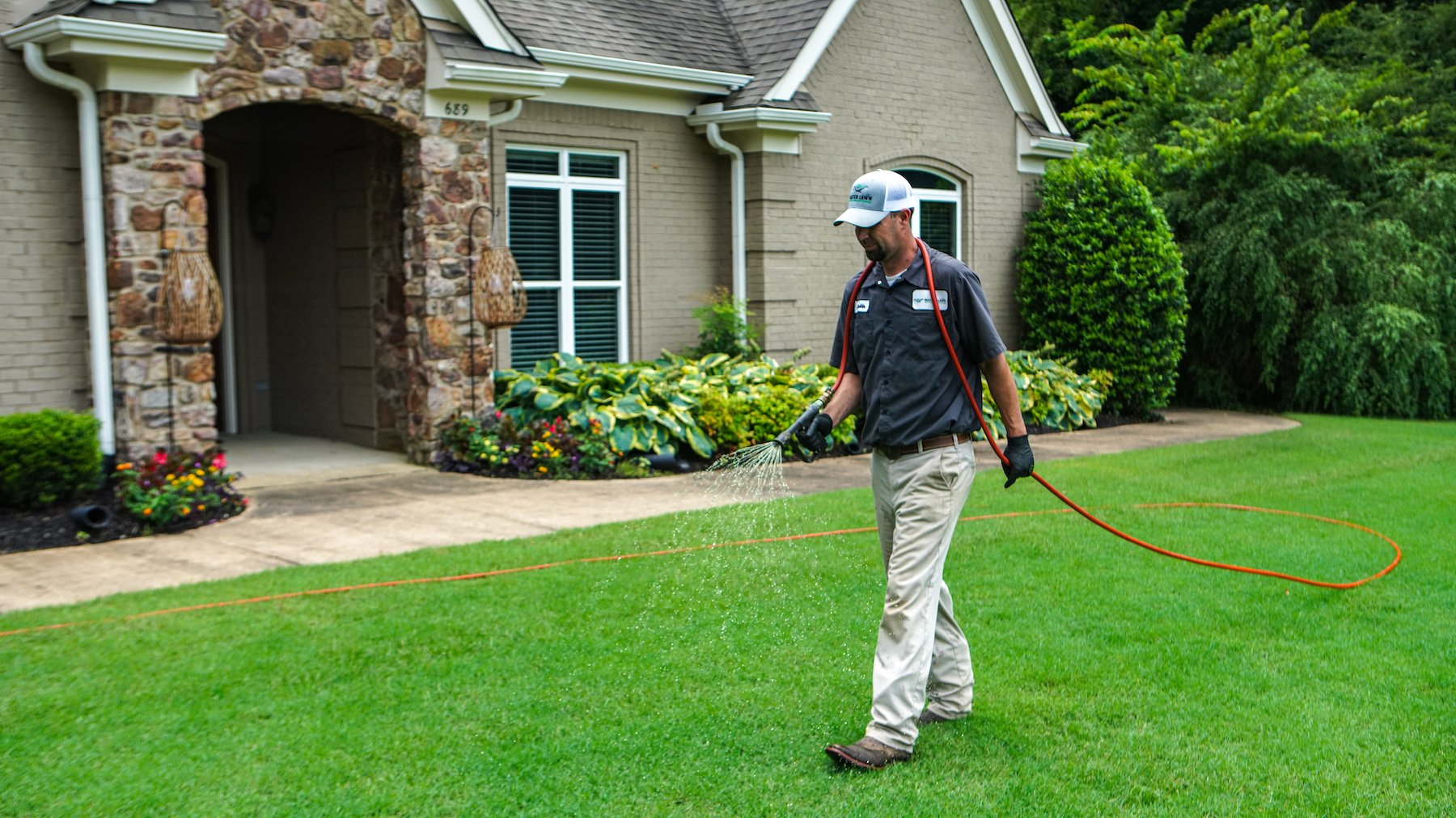 lawn care technician spraying flea and tick preventative