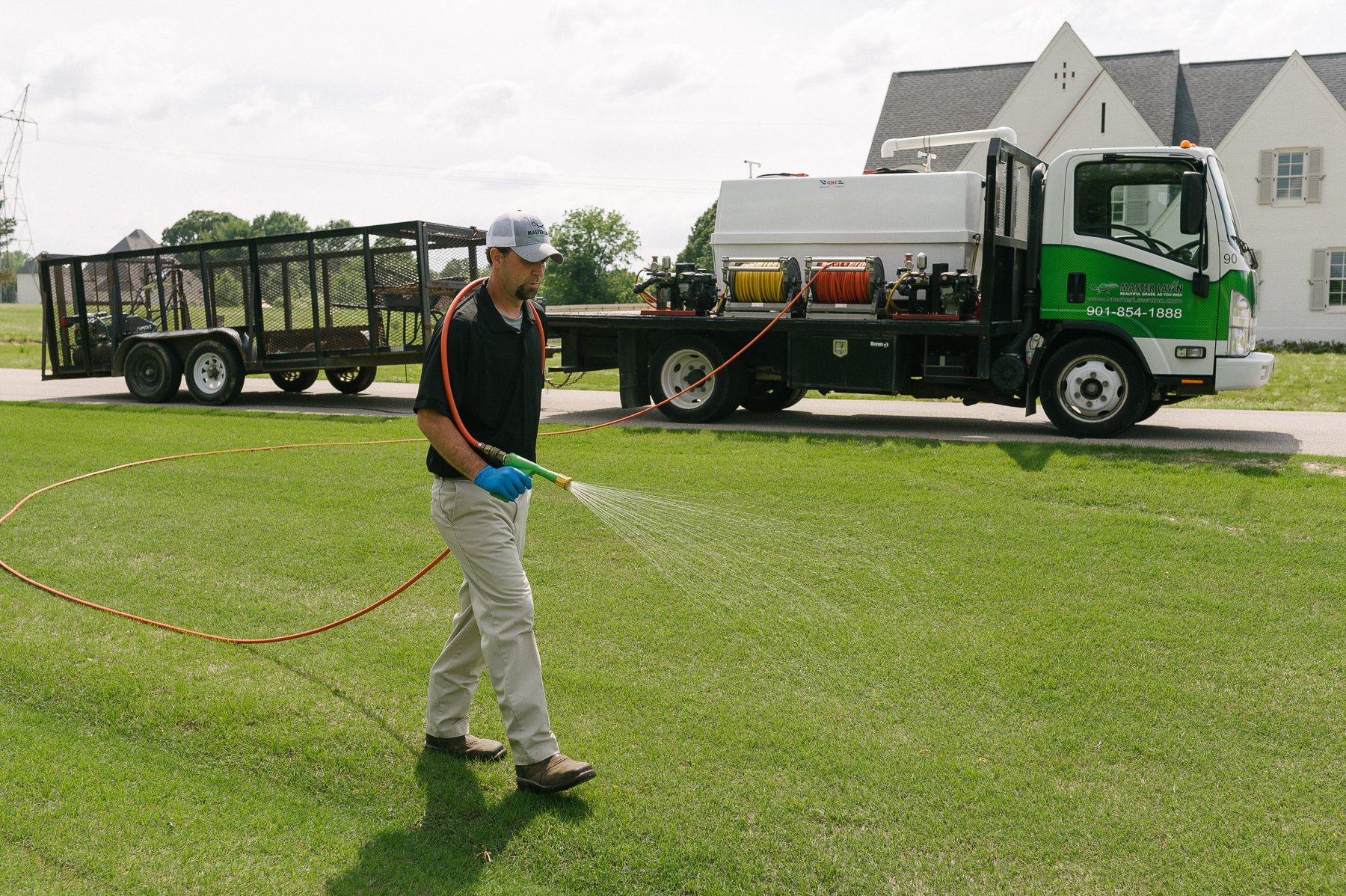 Master Lawn lawn care technician spraying yard