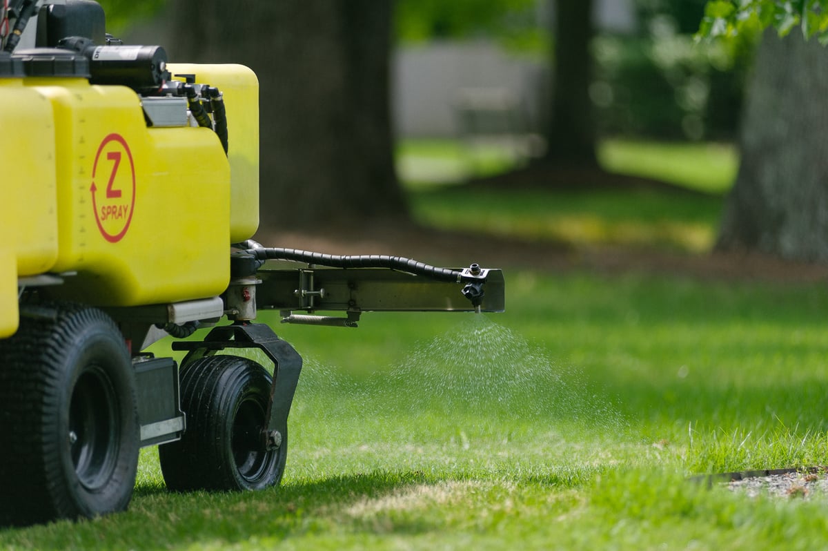 z sprayer putting down liquid fertilizer on grass
